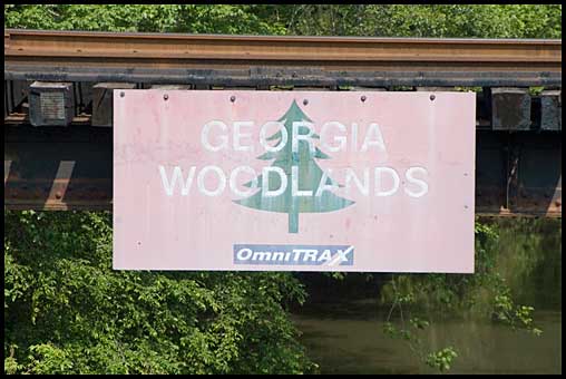 Georgia Woodlands-OmniTRAX sign on railroad trestle near Ficklin